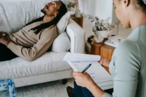 man lying on couch talking to a counselor