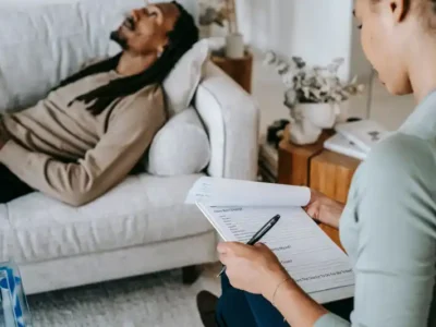 man lying on couch talking to a counselor