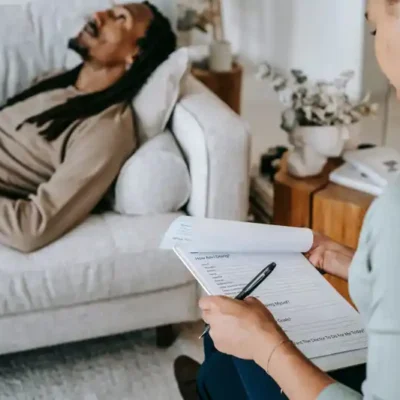 man lying on couch talking to a counselor